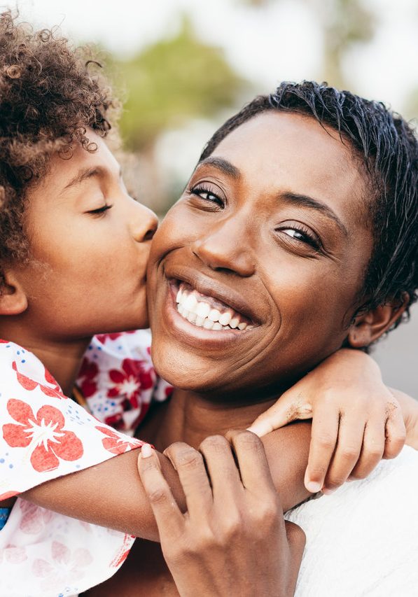 happy-young-mother-having-fun-with-her-child-summer-day-daughter-kissing-her-mum-outdoor_Easy-Resize.com